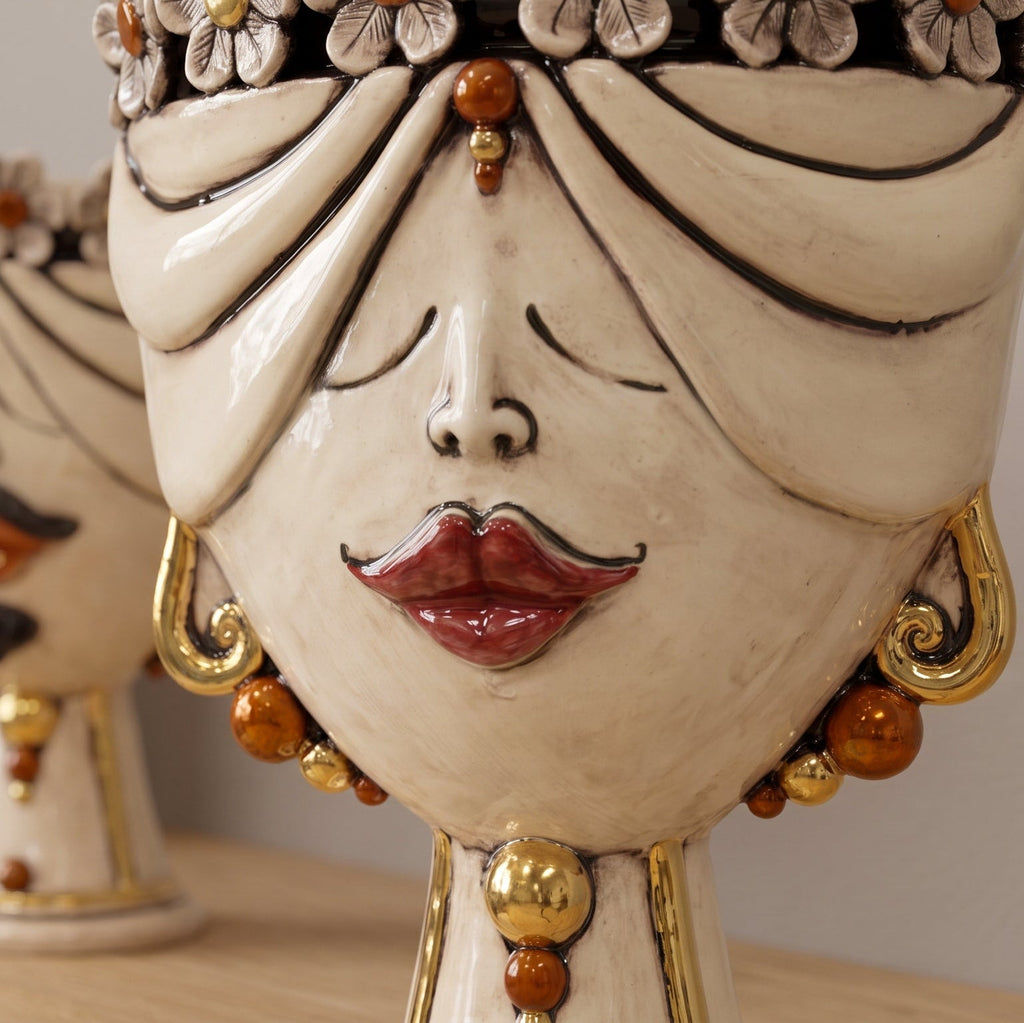 Detail of the female Zahira head with flowers: red lips, gold earrings and amber beads
