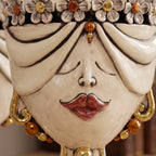 Close-up of the female Zahira head with flowers, closed eyes and mother-of-pearl drapery
