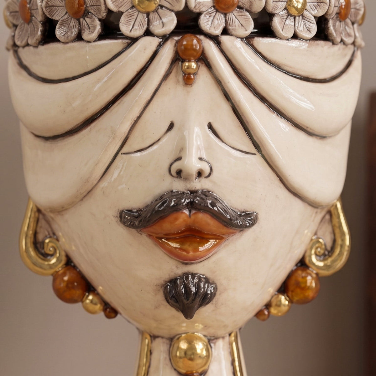 Close-up of the male Zahira head with a crown of flowers and amber beads