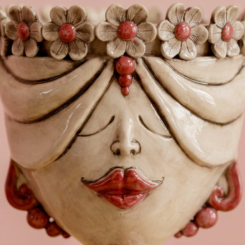 Detail des Zahira-Kopfs mit Blumen: handmodellierte Blütenblätter, geschlossene Augen und rote Lippen