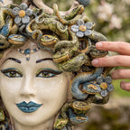 Detail of the Medusa head with flowers: green snakes, blue flowers and hand-painted blue lips