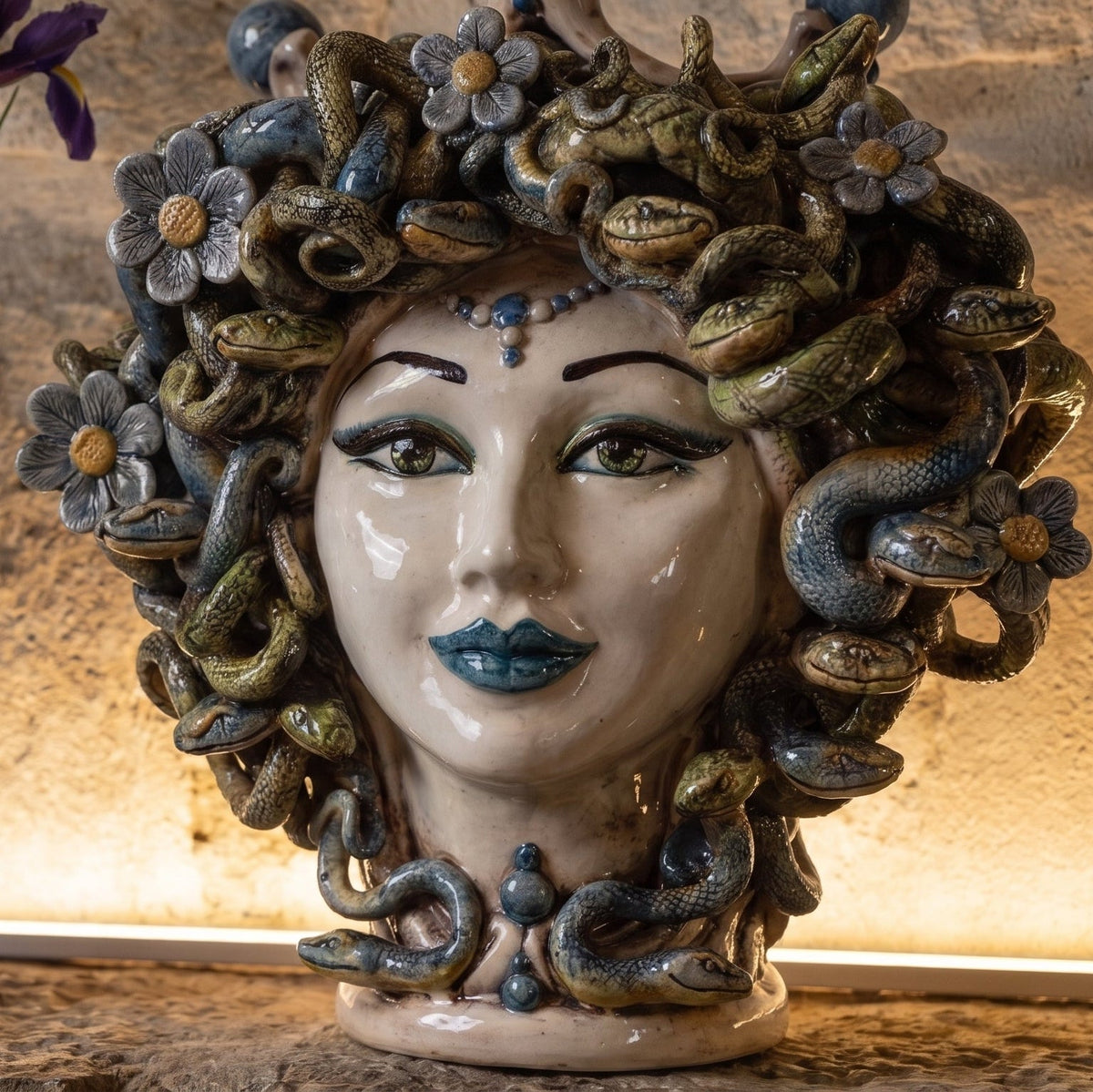 Detail of the Medusa head with flowers: mother-of-pearl face, blue lips and serpent hair