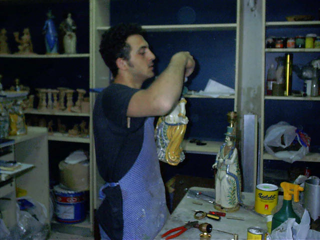 A Sofia workshop ceramicist hand-painting a figurine, among shelves of colours and brushes
