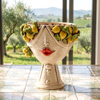 Female Zahira head with Sicilian lemons in mother of pearl and red lips, on a majolica-tiled table
