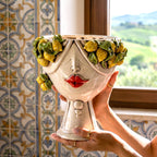 Female Zahira head with lemons held in two hands, against a wall of Sicilian majolica tiles