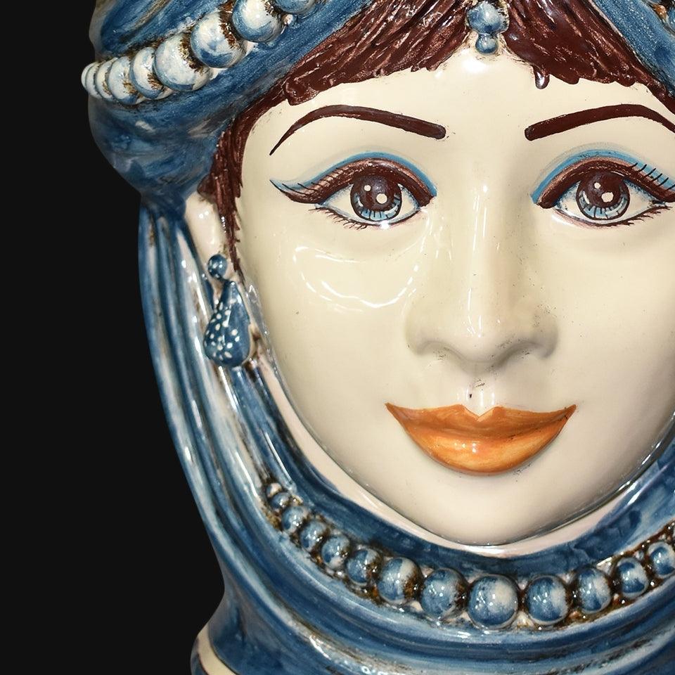 Handgefertigte Keramik aus Caltagirone mit weiblichem Gesicht und blauen Details, traditionelle sizilianische Kunst