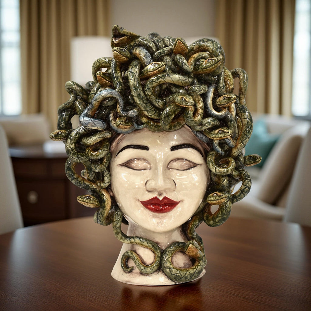 Testa Medusa Sognia a occhi chiusi in madreperla antichizzata, su un tavolo in legno